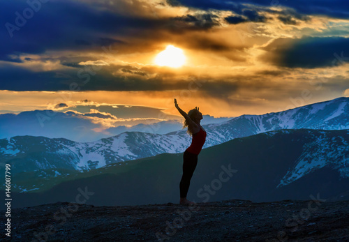 Young woman doing yoga in the mountains
