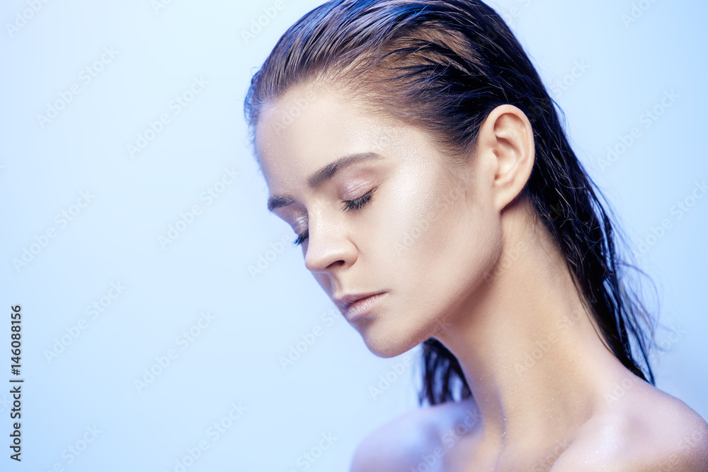 Naklejka premium Beautiful woman face portrait close up on blue