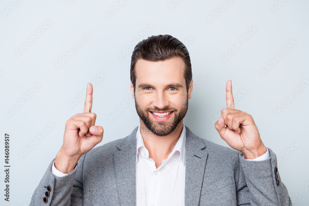 Close up portrait of smiling handsome man in shirt and jacket pointing up with his fingers Close up portrait of smiling handsome man in shirt and jacket pointing up with his fingers