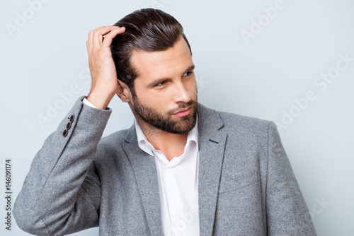 Close up portrait of handsome confident masculine man in jacket touching his hair