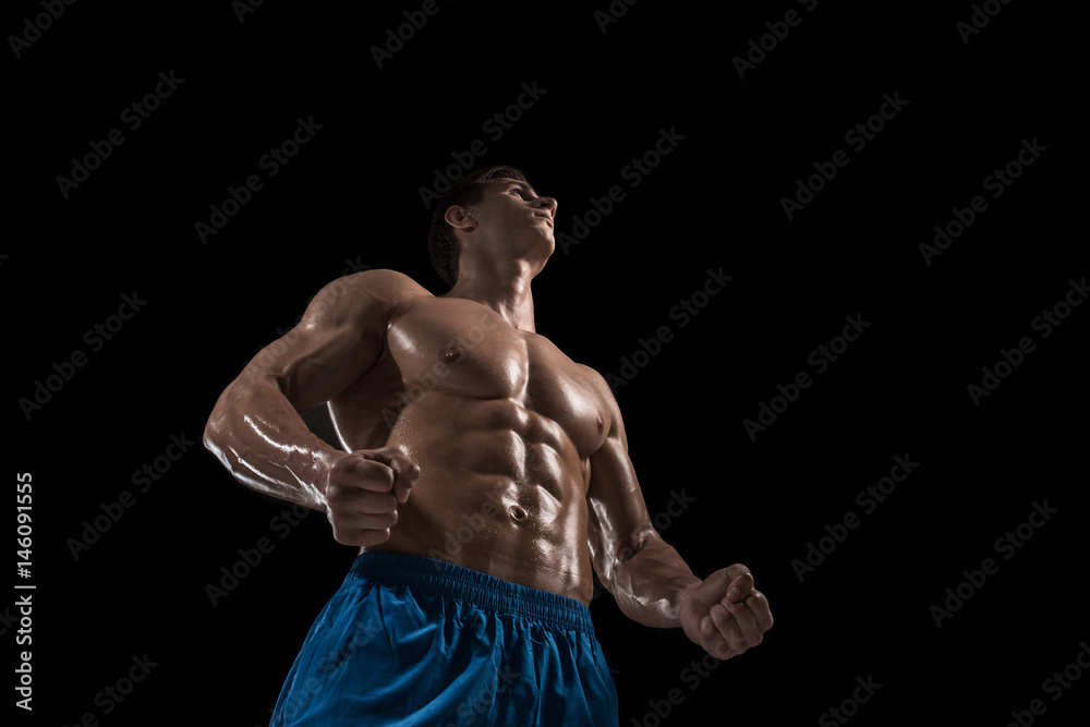 Fototapeta premium Muscular and fit young bodybuilder fitness male model posing over black background.