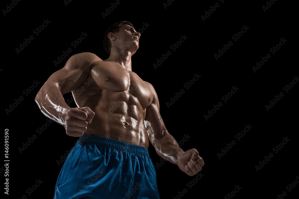 Fototapeta premium Muscular and fit young bodybuilder fitness male model posing over black background.