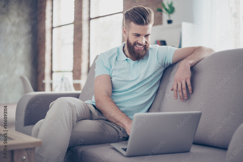 Young bearded man is making shopping online sitting at home on the cozy sofa Young bearded man is making shopping online sitting at home on the cozy sofa