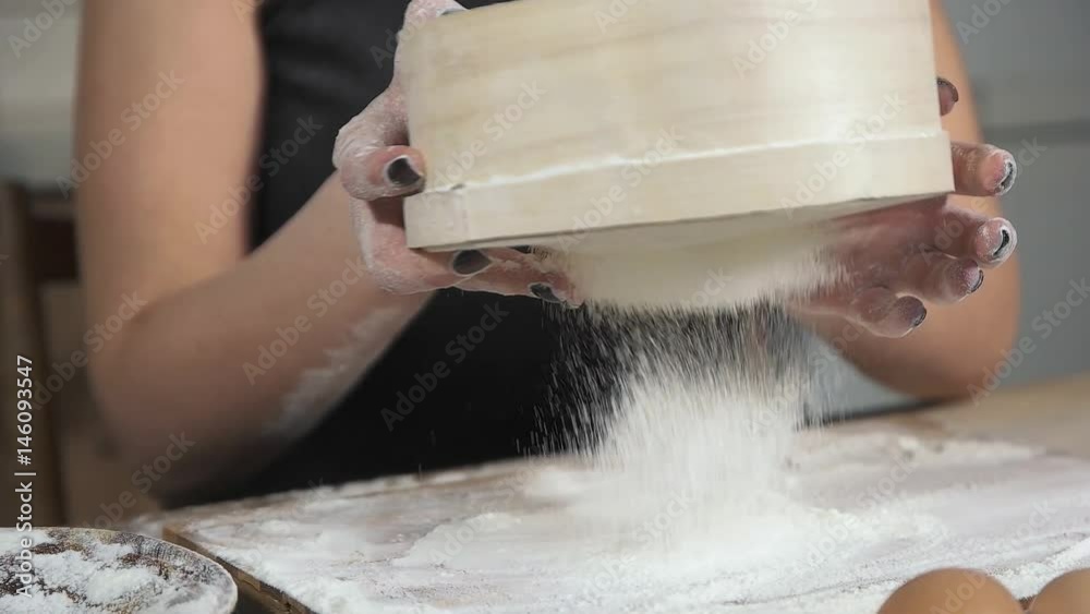 Female hands sifted flour dough