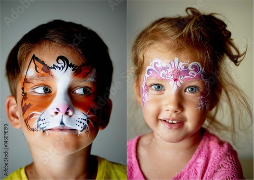6 years old boy with blue eyes face painting of a cat or tiger.Pretty exciting blue-eyed girl of 2 years with a face painting