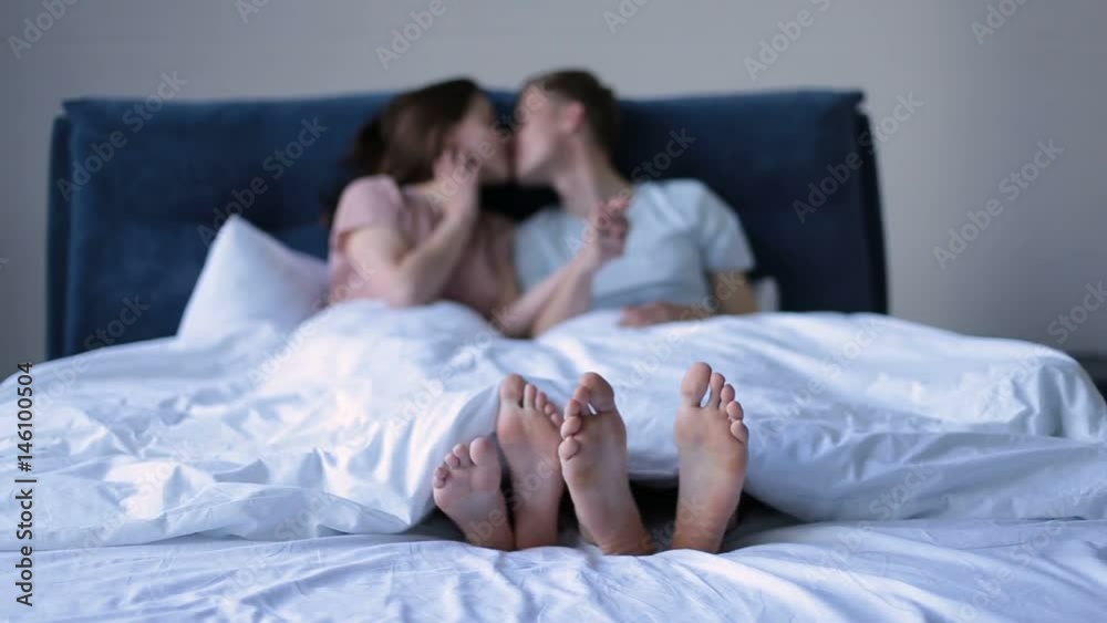 Close-up human feet together under the blanket Close-up human feet together under the blanket
