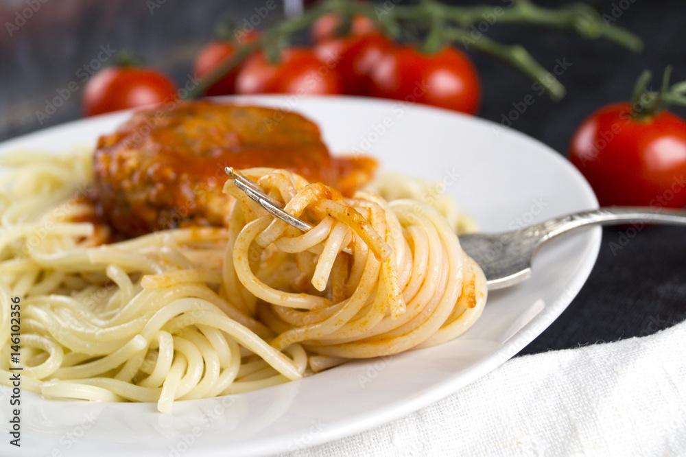 Spaghetti on a fork. Pasta with fresh tomatoes and meatballs