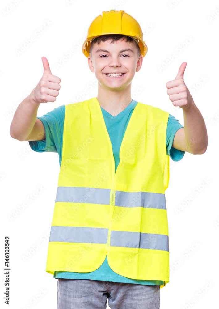 Emotional portrait of handsome caucasian teen boy wearing safety yellow hard hat. Happy child making thumbs up gesture and looking at camera. Funny cute guy - engineer.