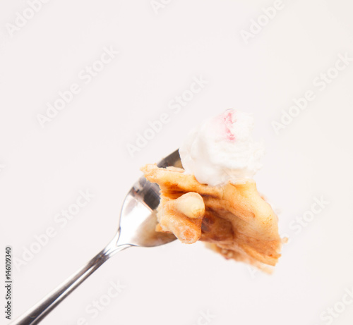 Polish-Lithuanian traditional spit cake ('tree cake') -sekacz (polish) or sakotis (lithuanian) with some ice-cream on a fork on a white background photo