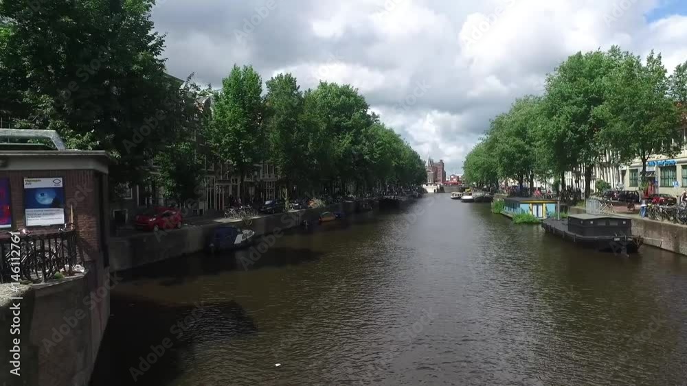 AMSTERDAM, NETHERLANDS - JULY 2, 2016 : View of popular Amsterdam canals with historical houses. Amsterdam is a touristic city. AMSTERDAM, NETHERLANDS - JULY 2, 2016 : View of popular Amsterdam canals with historical houses. Amsterdam is a touristic city.