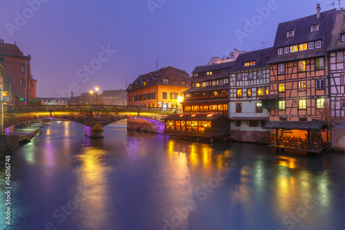 Traditional Alsatian half-timbered houses and bridge in Petite France during twilight blue hour, Strasbourg, Alsace, France