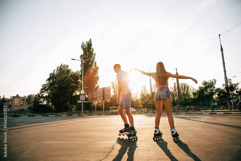 Fototapeta premium 894471 a couple roller-skating at sunset.