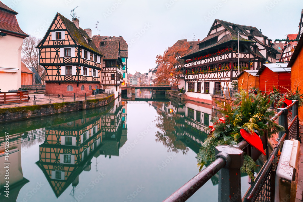Traditional Alsatian half-timbered houses in Petite France with mirror reflections in the morning, Strasbourg, Alsace, France