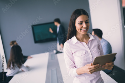 Beautiful businesswoman using tablet to gather information in office