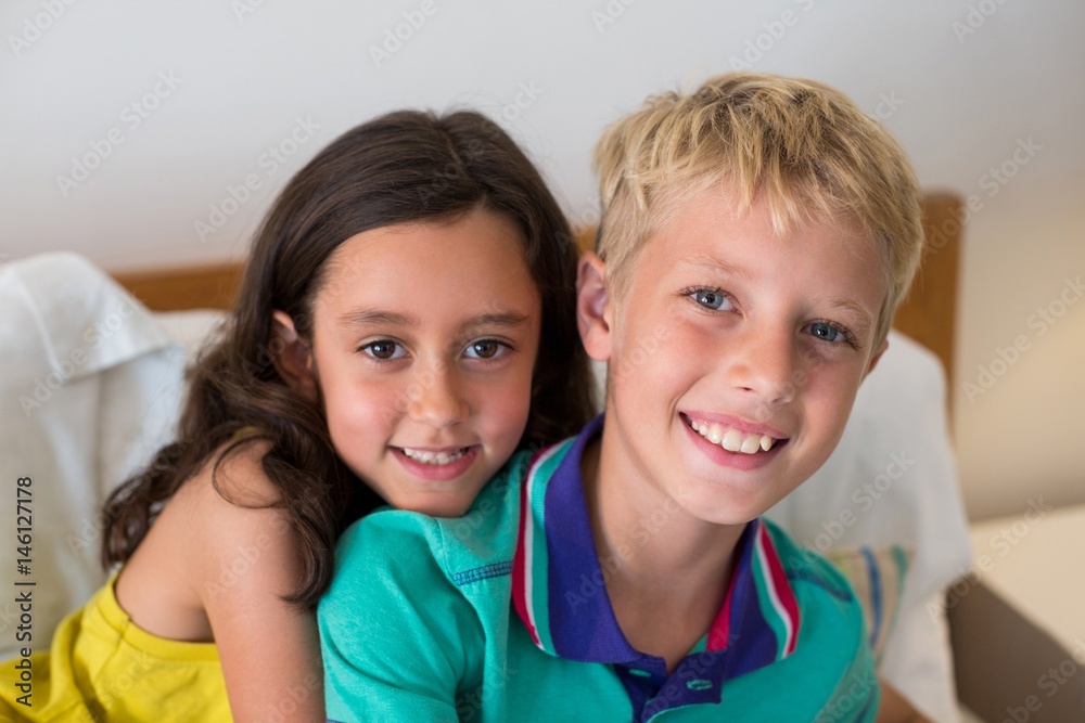 Portrait of siblings embracing each other on bed in bedroom Portrait of siblings embracing each other on bed in bedroom