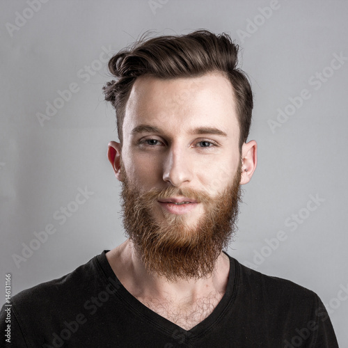 Confident and convincing young man isolated on gray background