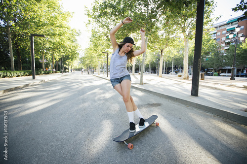 Young woman riding on her longboard. © juananbarros