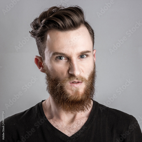 Very angry young man isolated on gray background