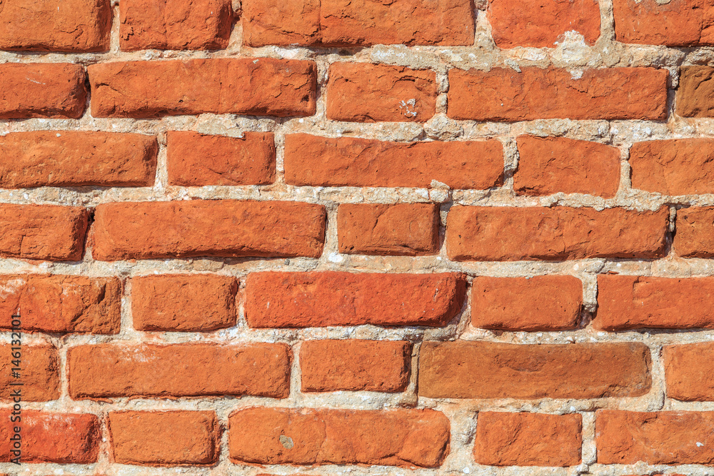 Old brickwork with broken bricks on lime mortar