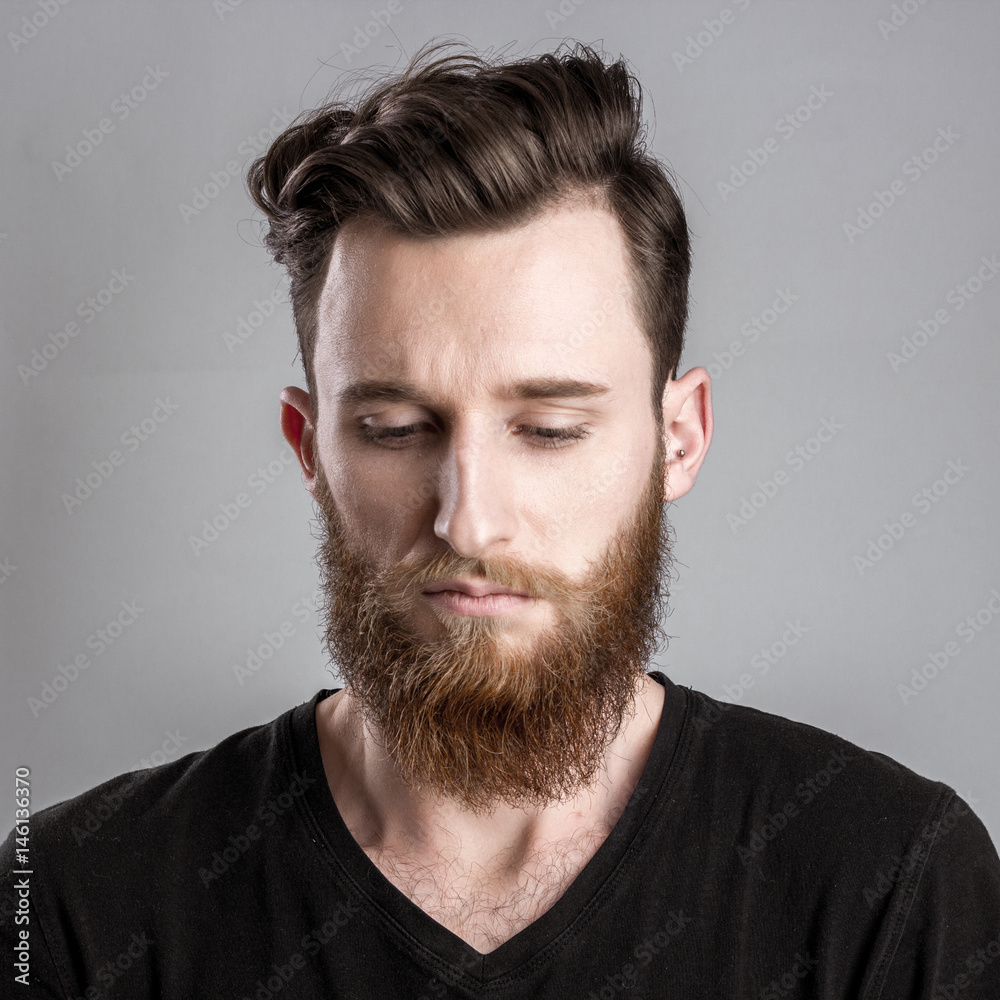 Fototapeta premium Sad and unhappy young man isolated on gray backround