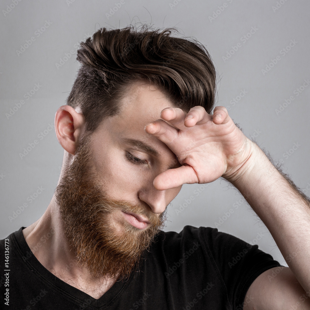 Obraz premium Sad and unhappy young man isolated on gray backround
