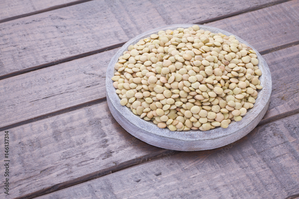Pile of lentils on wooden background (Lens culinaris)

