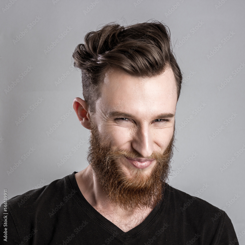 Obraz premium Treacherous and crafty young man isolated on gray background