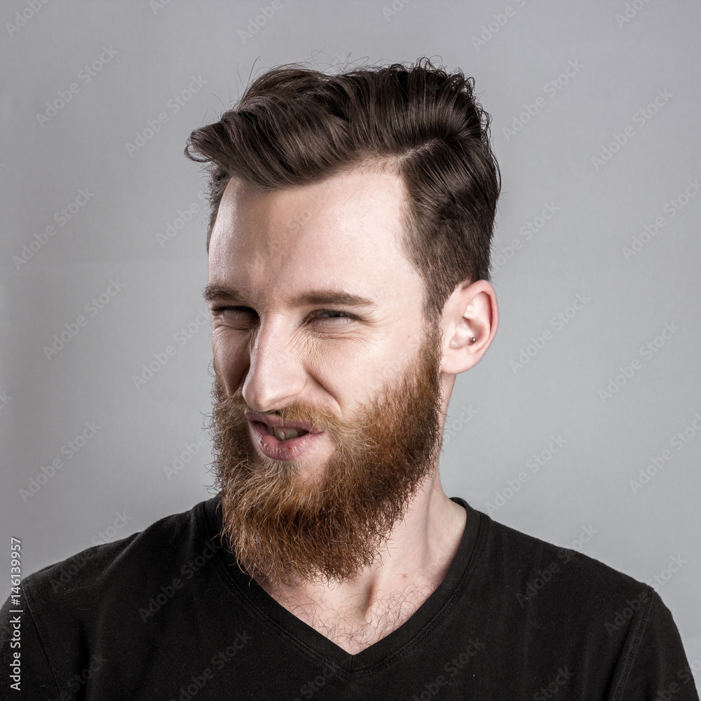 Obraz premium Treacherous and crafty young man isolated on gray background