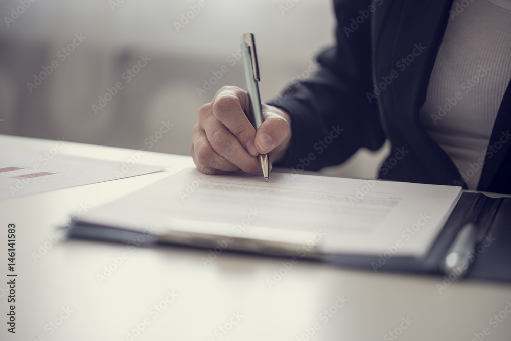 Businesswoman signing a contract or document - obrazy, fototapety, plakaty 