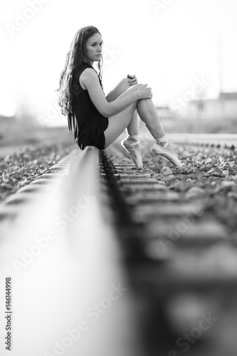 Ballerina posing on the railroad track. photo