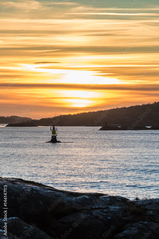 Fototapeta premium Orange and yellow sky above harbor port coast sunset sailing boat