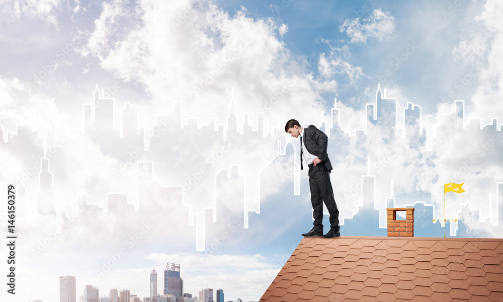 Businessman looking down from roof and modern cityscape at background. Mixed media Businessman looking down from roof and modern cityscape at background. Mixed media