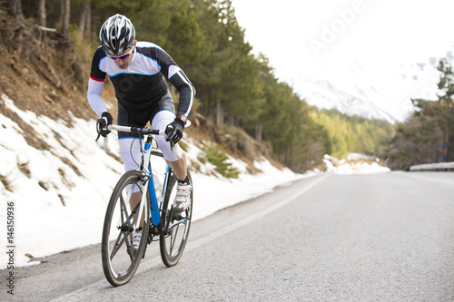 Cyclist man riding mountain bike on a mountain road.