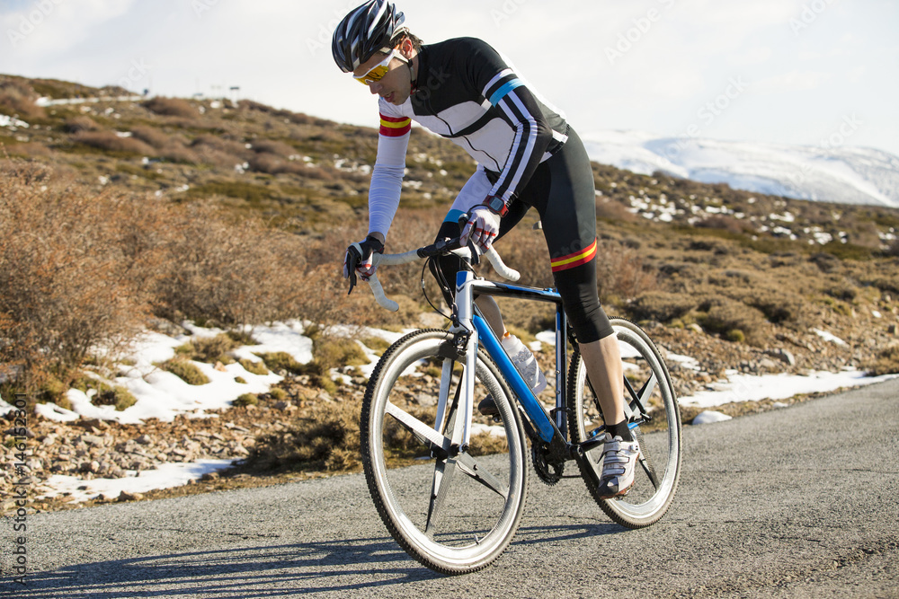Fototapeta premium Cyclist man riding mountain bike on a mountain road