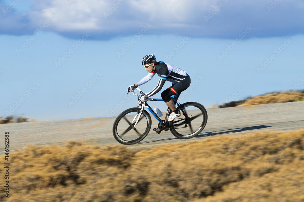 Cyclist man riding mountain bike on a mountain road