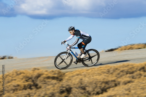 Fototapeta Naklejka Na Ścianę i Meble -  Cyclist man riding mountain bike on a mountain road