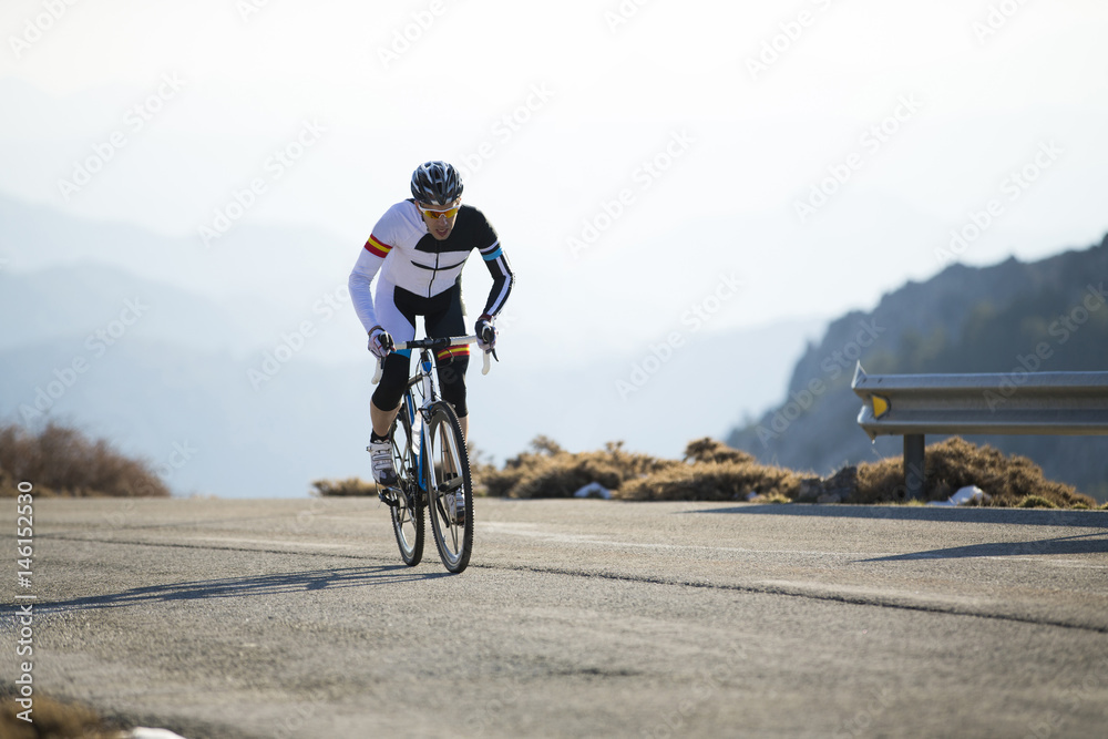 Obraz premium Cyclist man riding mountain bike on a mountain road