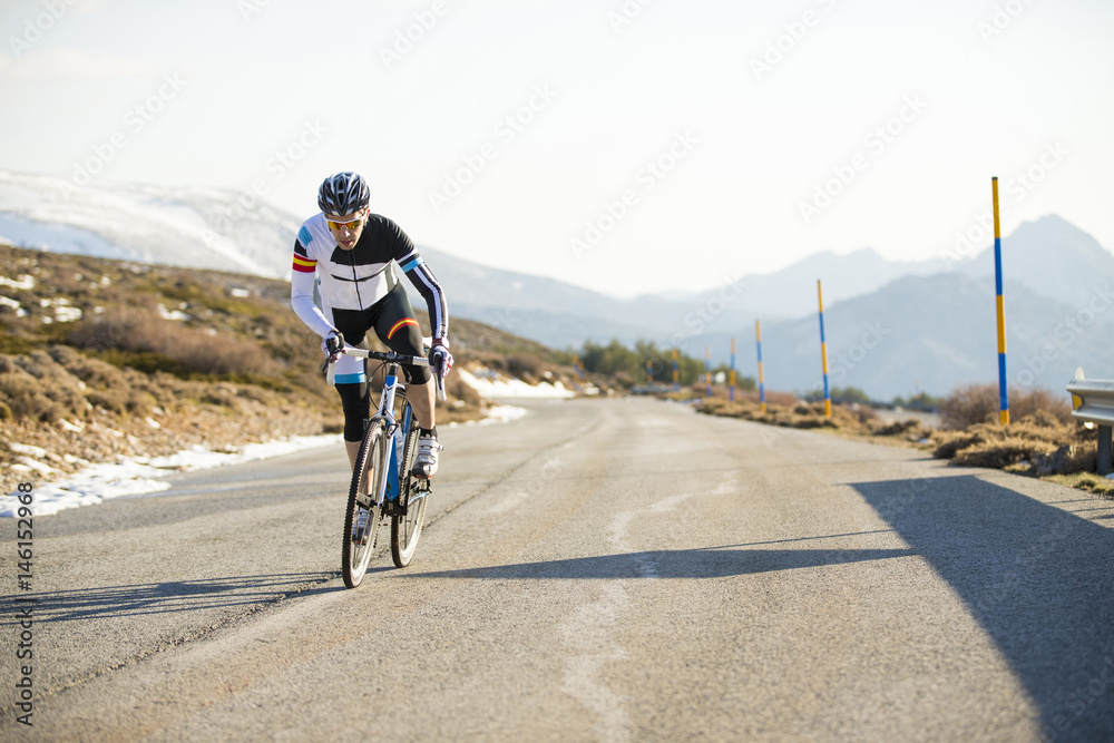 Obraz premium Cyclist man riding mountain bike on a mountain road.