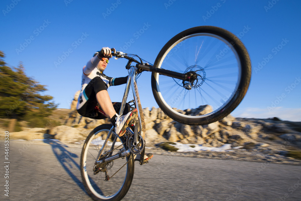 Fototapeta premium Cyclist man riding mountain bike on a mountain road