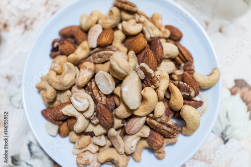 Macro closeup of salted mixed nuts in plate