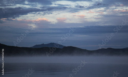 Borovoe lake during sunrise, sleeping knight mountain and smoke on the water, Burabay National park in Northern Kazakhstan.