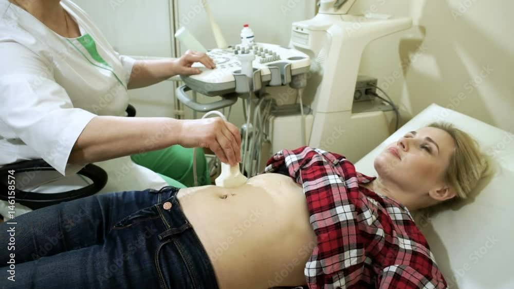 Female doctor examining the woman's abdominal organs using an ...
