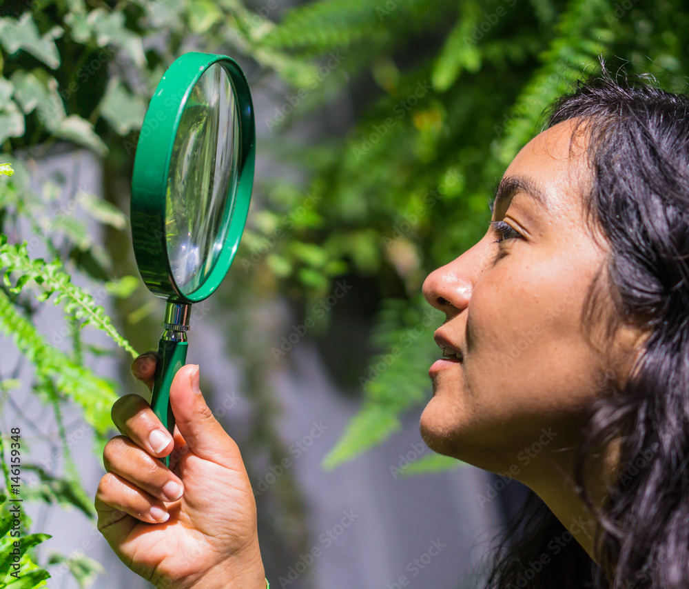 young woman looking for details of butterflies using a magnifying glass
young woman looking for details of butterflies using a magnifying glass