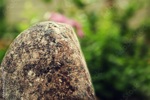 A large stone on a green nature background.