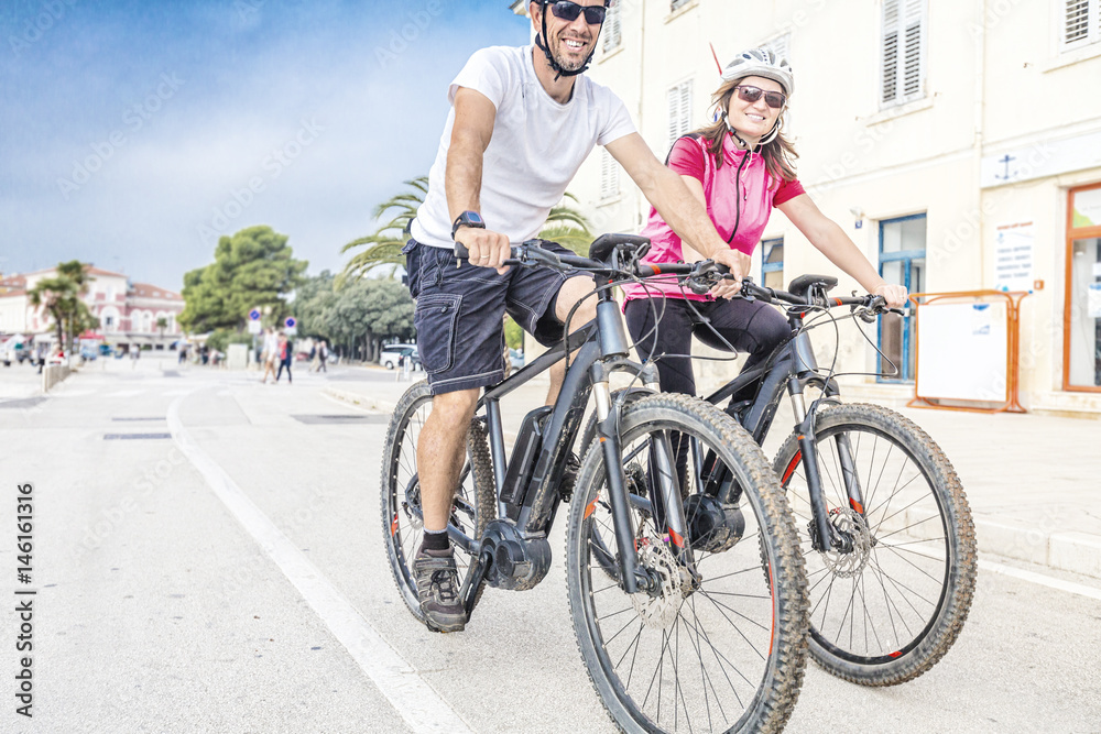 Fototapeta premium Pärchen mit dem E-Bike im Urlaub im Süden