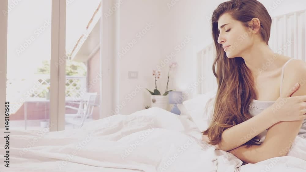 Sad woman sitting in bed feeling lonely and depressed slow motion dolly Sad woman sitting in bed feeling lonely and depressed slow motion dolly