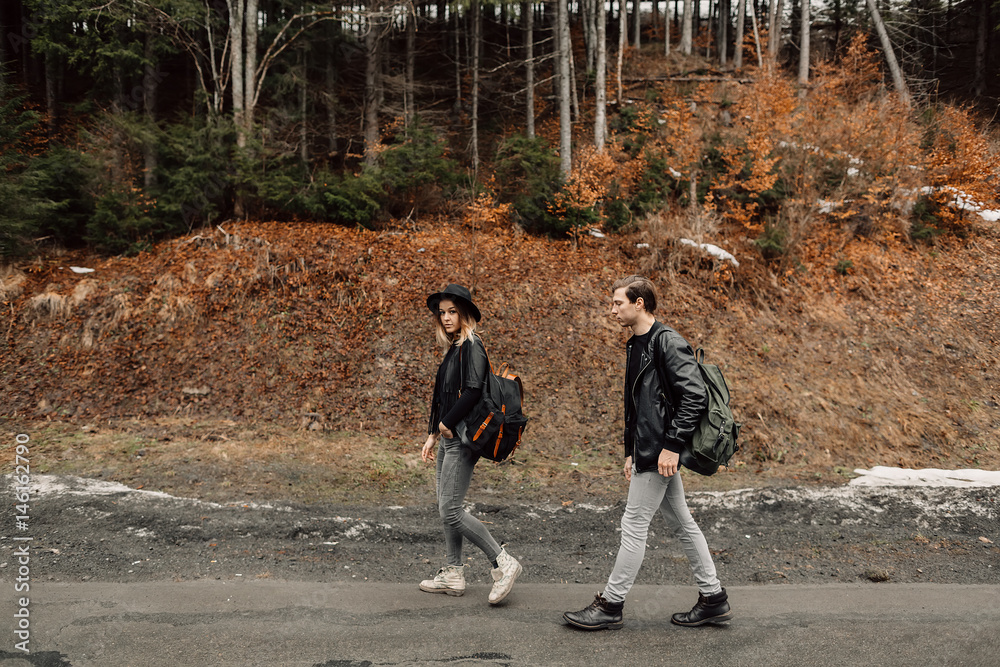 the couple are traveling. Boy and girl with backpacks travel. The couple is on the road. The girl looks up. Girl goes for a man. Travel the couple are traveling. Boy and girl with backpacks travel. The couple is on the road. The girl looks up. Girl goes for a man. Travel
