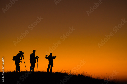 Silhouette of aphotographers top of mountain on sunset. © soda426