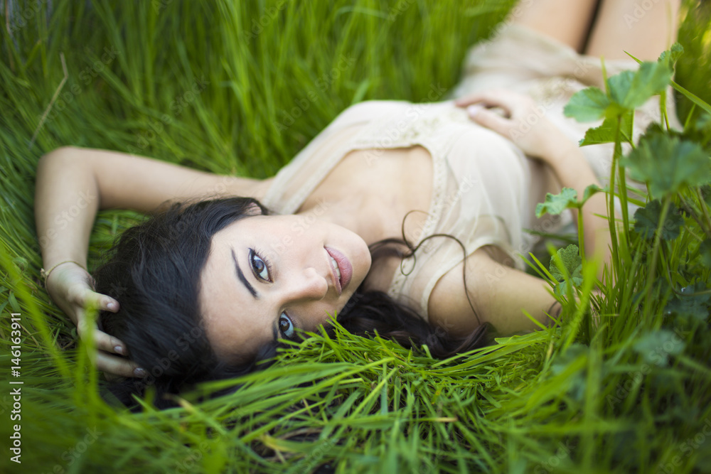 Beautiful Girl lying on the Field.Green Grass. Happy and Smiling Beautiful Girl lying on the Field.Green Grass. Happy and Smiling