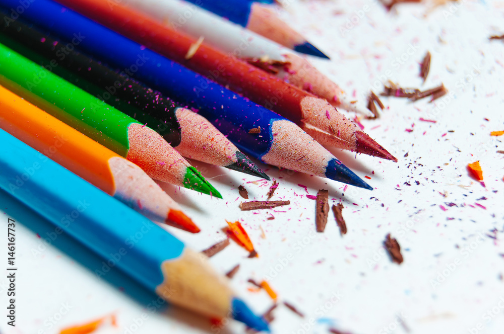 Many different colored pencils on paper background Many different colored pencils on paper background